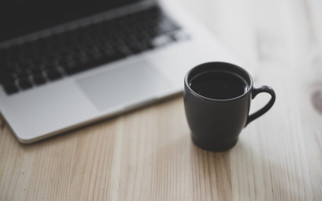 Eine Kaffeetasse steht vor einem Laptop. Das Bild symbolisiert, wie einfach und bequem sich Menschen bei der Hermann Schulten GmbH bewerben können.