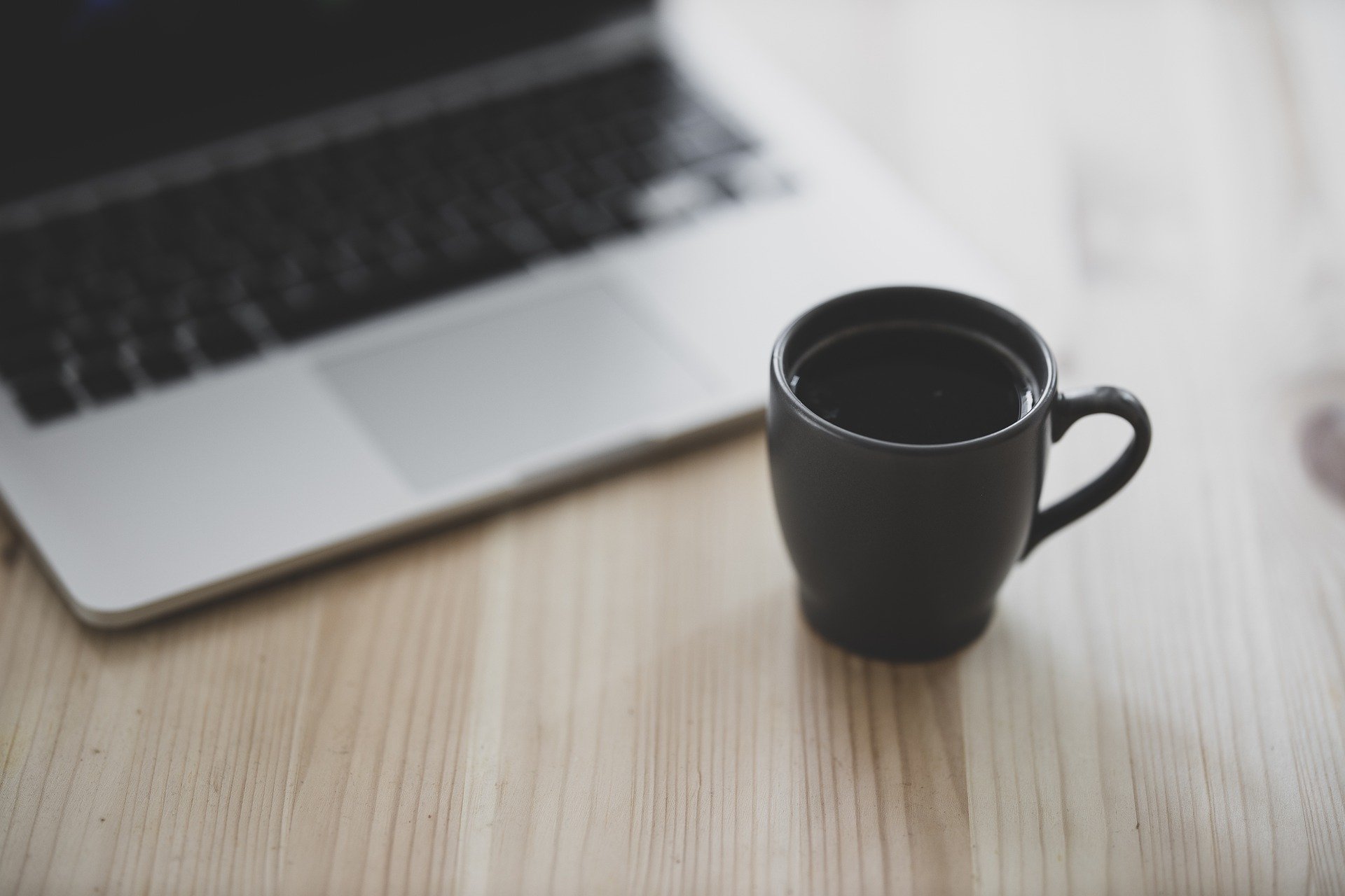 Eine Kaffeetasse steht vor einem Laptop. Das Bild symbolisiert, wie einfach und bequem sich Menschen bei der Hermann Schulten GmbH bewerben können.
